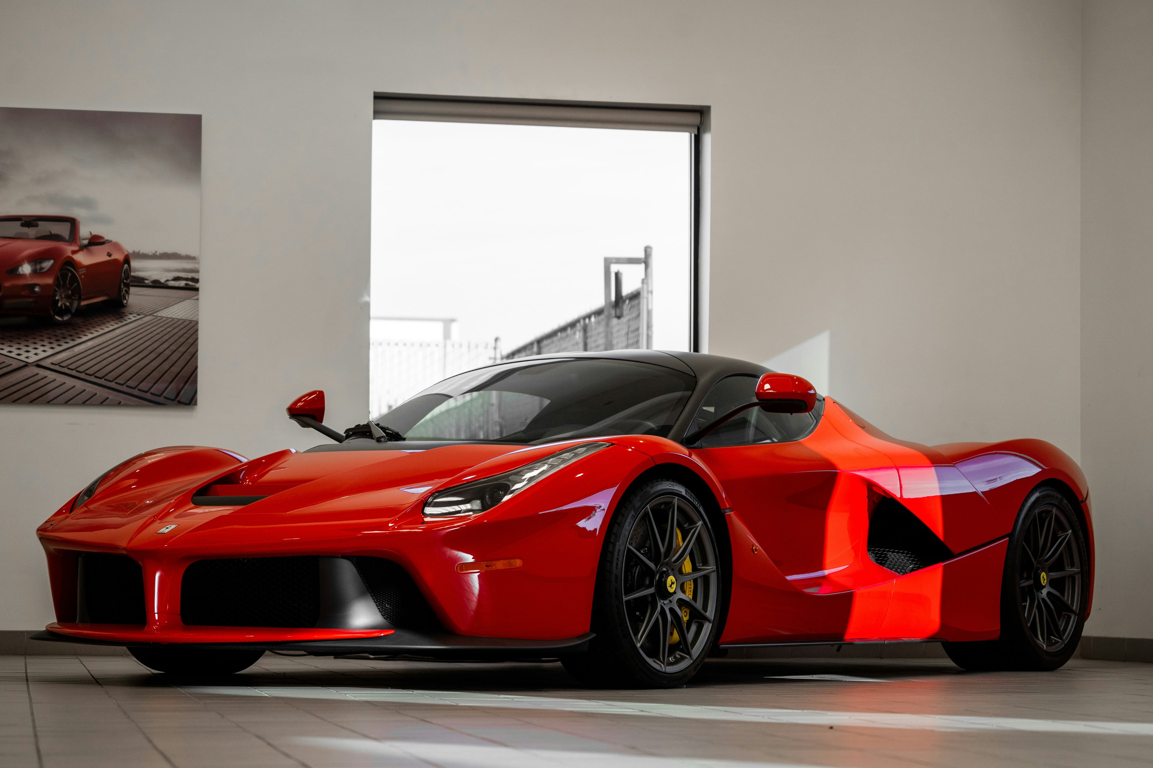 Red Ferrari LaFerrari in a sunlit showroom