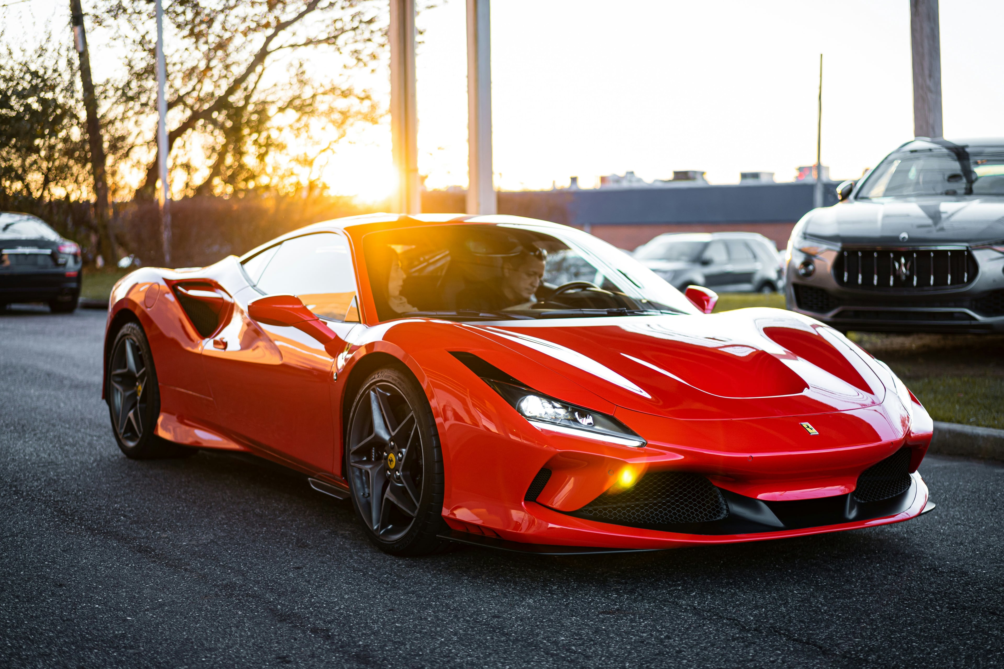 Red Ferrari F8 Tributo glowing in golden sunset light