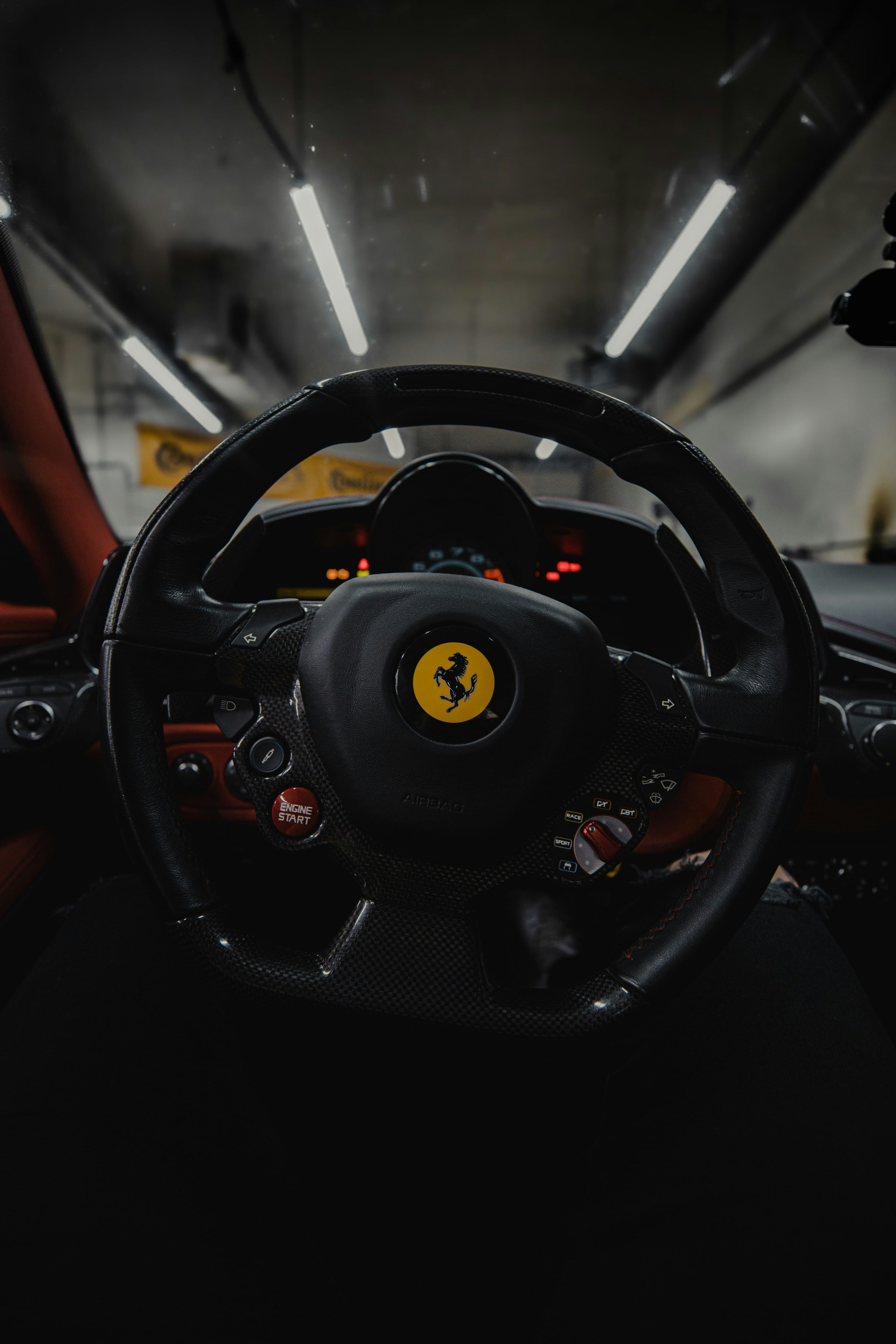 Ferrari steering wheel and instrument cluster in a dim garage