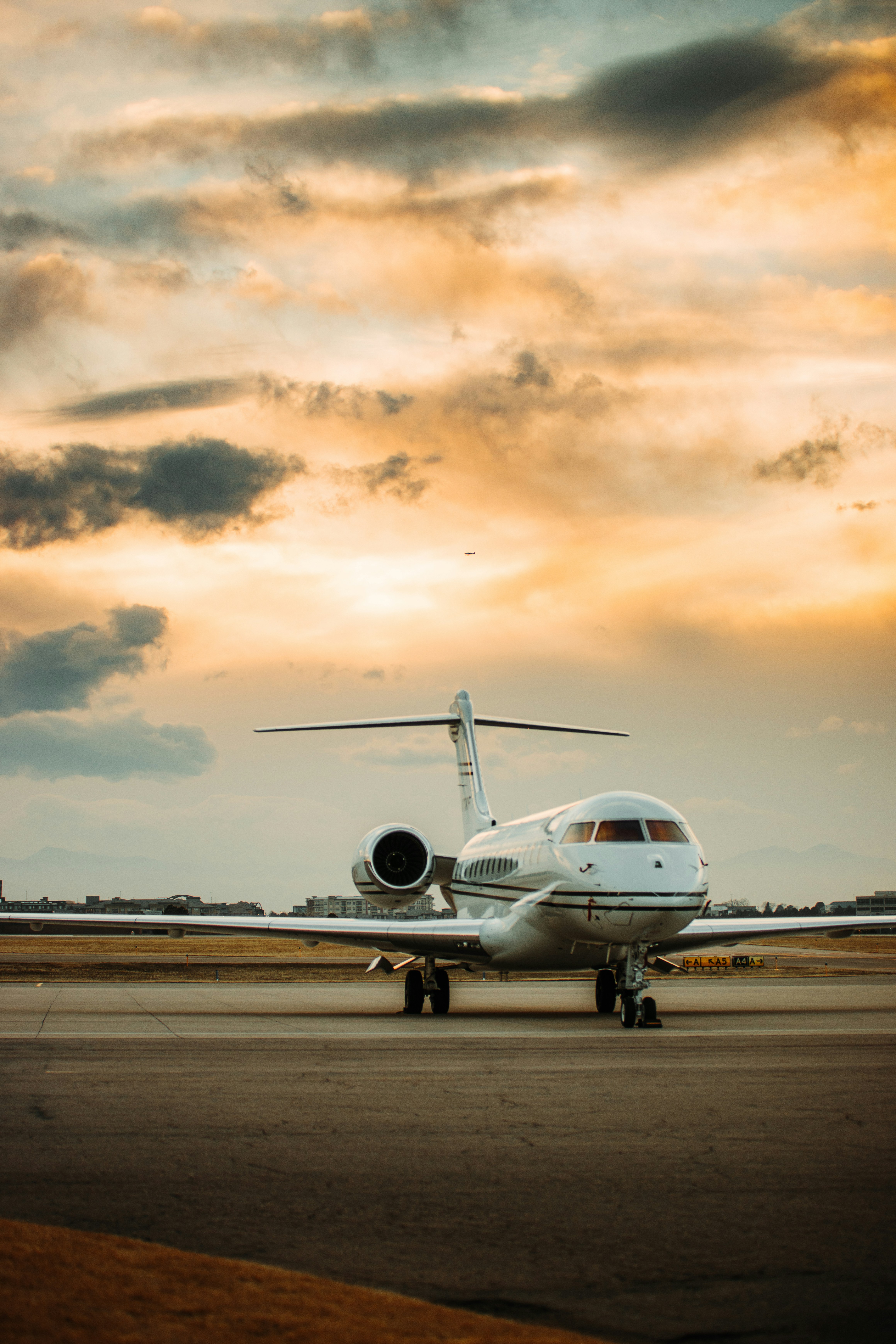 Private jet on the runway beneath a golden sunset sky