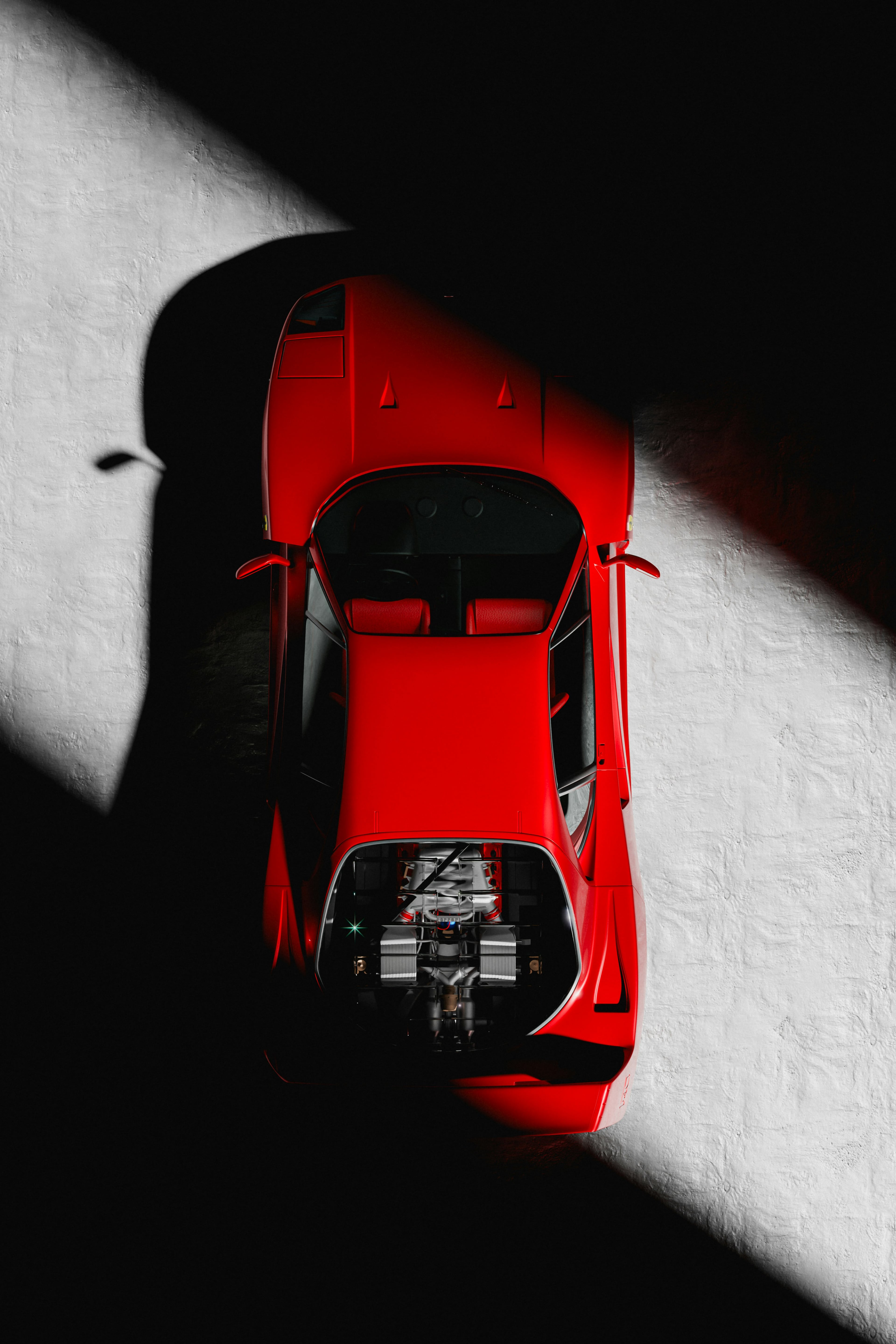 Overhead view of a red Ferrari in a shaft of light